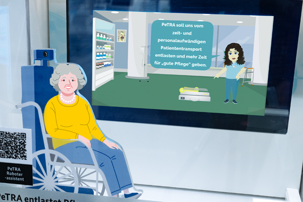 Ein Bildschirm mit einem Erklärvideo, davor ein Bild einer älteren Dame im Rollstuhl.