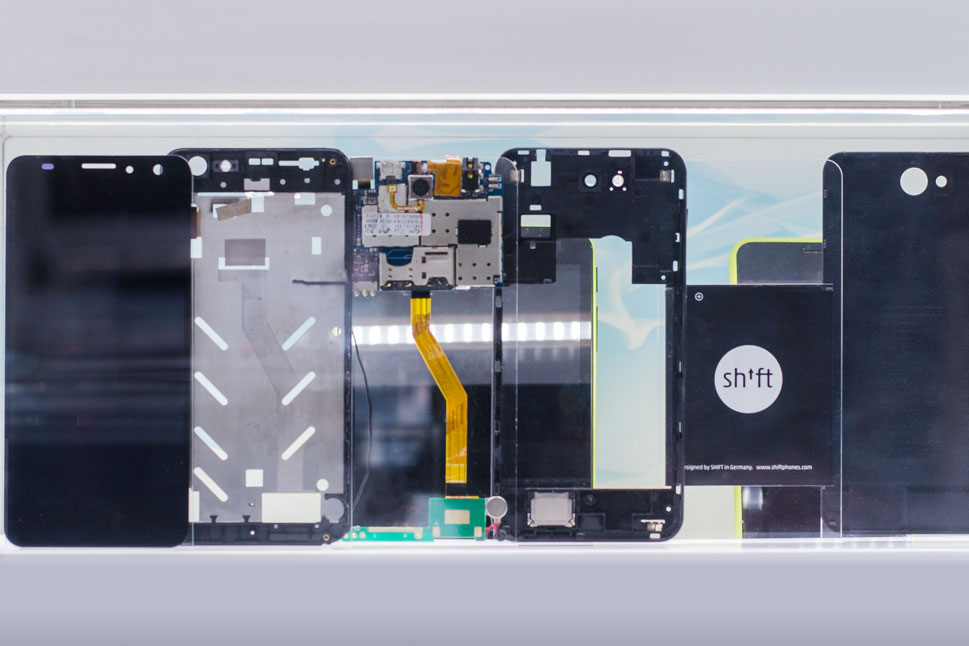 Die einzelnen Schichten des Smartphones vom Display über Prozessor, Akku hin zum Deckel sind nebeneinander aufgereiht.