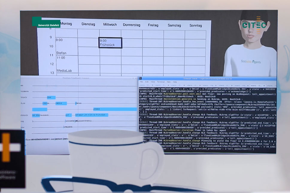 Auf einem Bildschirm ist die Assistenzsorftware zu sehen: Im Hintergrund das Front End, im Vordergrund ein Fenster mit der Programmierung.